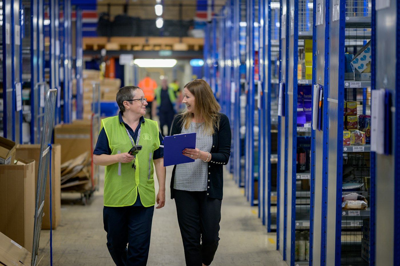 Deux membres de l'équipe logistique en gilet haute visibilité dans un entrepôt